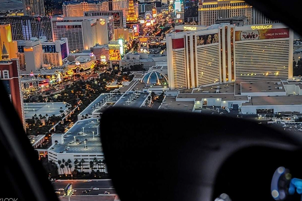Las Vegas Views Hubschraubernachtflug-Erlebnis - Der Las Vegas Hubschraubernachtflug bietet ein unvergessliches Erlebnis und ermöglicht Ihnen einen Vogelblick auf den berühmten Las Vegas Strip. Während Sie hoch über der Stadt schweben, sehen Sie die funkelnden Lichter ikonischer Wahrzeichen wie die Bellagio-Brunnen, den Eiffelturm im Paris Las Vegas und die Luxor Pyramide. Der Nachthimmel und die beleuchteten Gebäude schaffen eine magische Atmosphäre und machen diesen Hubschrauberrundflug zu einer perfekten Möglichkeit, Las Vegas in all seiner Pracht zu erleben. Ob Sie einen besonderen Anlass feiern oder einfach nach einem einzigartigen Abenteuer suchen, dieses Erlebnis bietet atemberaubende Ausblicke und Erinnerungen für ein Leben lang. Mit erfahrenen Piloten, die Ihren Flug steuern, können Sie sich entspannen und das beeindruckende Panorama einer der spannendsten Städte der Welt genießen. Verpassen Sie nicht die Gelegenheit, Las Vegas von oben zu sehen und seine lebendige Energie und Lichter aus der Luft zu erleben. Las Vegas Views Hubschraubernachtflug-Erlebnis - Bild 2 von 5