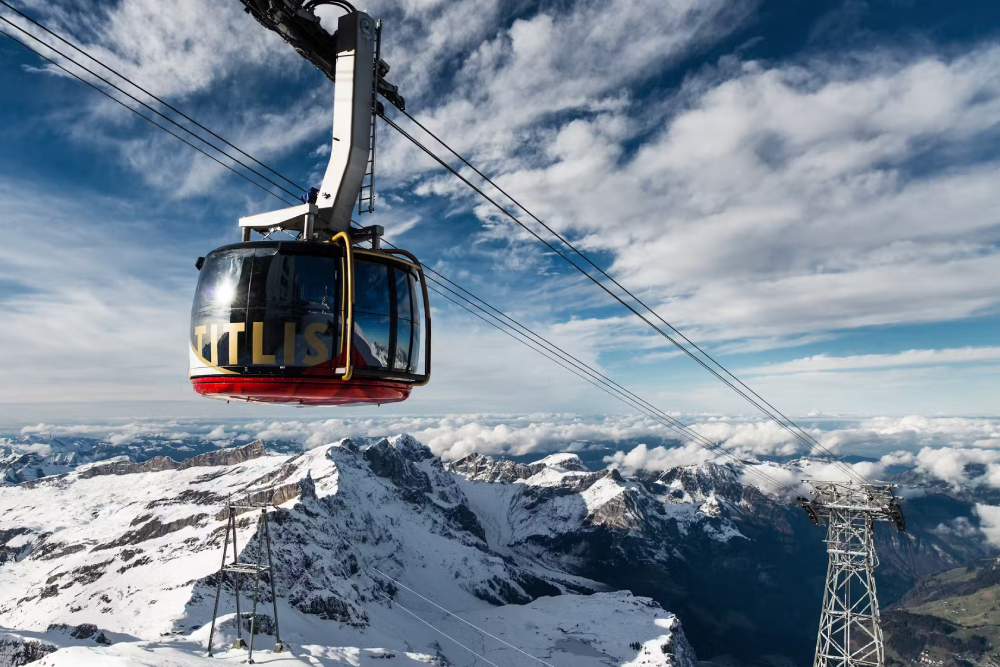 Excursión al Monte Titlis - Experimenta los impresionantes Alpes Suizos en una excursión al Monte Titlis desde Zúrich o Lucerna. Viaja en el primer teleférico giratorio del mundo, explora la Cueva de Glaciares, camina por el Puente Colgante de Titlis y disfruta de vistas panorámicas. Esta inolvidable aventura alpina incluye transporte de ida y vuelta y es perfecta para amantes de la naturaleza, familias y visitantes primerizos a Suiza. Descubre nieve, hielo y paisajes impresionantes durante todo el año en una de las excursiones montañosas más icónicas de Suiza. Excursión al Monte Titlis - Imagen 1 de 5