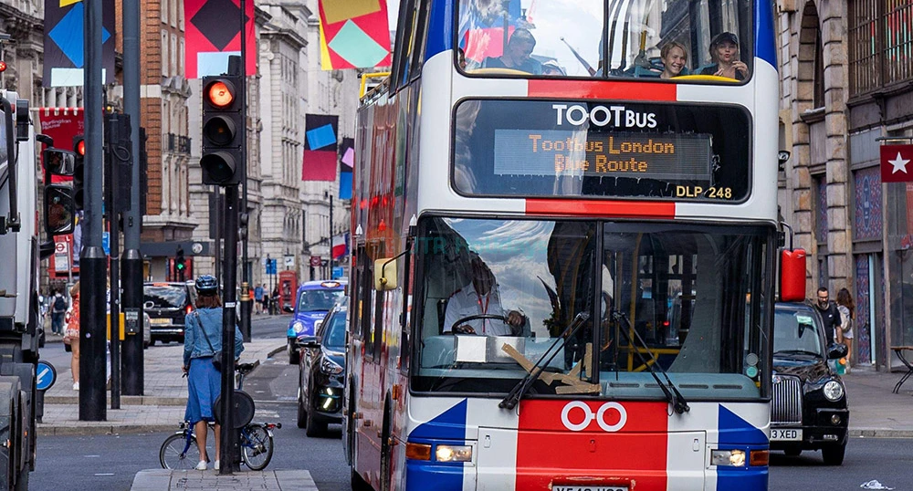 London Hop-On-Hop-Off Bus von Tootbus - Entdecken Sie das Beste von London mit dem Hop-On Hop-Off Bus von Tootbus. Fahren Sie mit einem offenen Doppeldeckerbus durch die Stadt und genießen Sie erstaunliche Ausblicke auf berühmte Wahrzeichen wie Big Ben, Buckingham Palace und das London Eye. Steigen Sie aus, wann immer Sie Museen, Parks und Einkaufsstraßen erkunden möchten. Steigen Sie dann wieder ein, wenn Sie bereit sind, Ihr Abenteuer fortzusetzen. Die Busse fahren häufig, so dass Sie nie lange warten müssen. Hören Sie unterhaltsame und interessante Audioguides während der Fahrt. Wählen Sie aus verschiedenen Routen, um alle Top-Sehenswürdigkeiten zu sehen. Es ist eine unterhaltsame, einfache und flexible Möglichkeit, London zu erkunden. Perfekt für Familien, Freunde und Erstbesucher London Hop-On-Hop-Off Bus von Tootbus - Bild 1 von 5