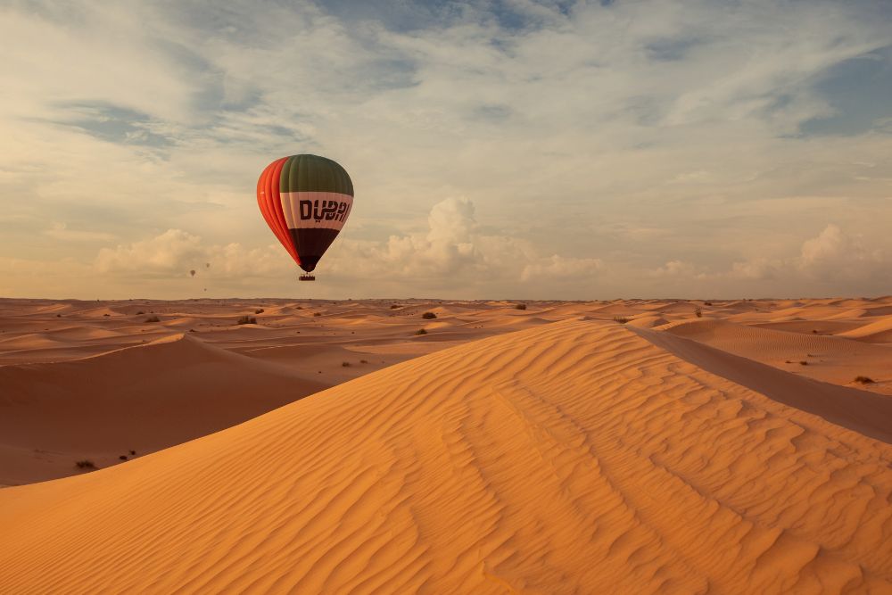 Dubai Hot Air Balloon Signature Experience - "Experience a breathtaking sunrise hot air balloon ride over Dubai’s desert with a drone light show, in-flight falcon display, and exclusive views of the Dubai Desert Conservation Reserve. Complete the journey with a Michelin-starred breakfast and a camel ride at a Royal Desert Retreat." Dubai Hot Air Balloon Signature Experience - Image 2 of 5