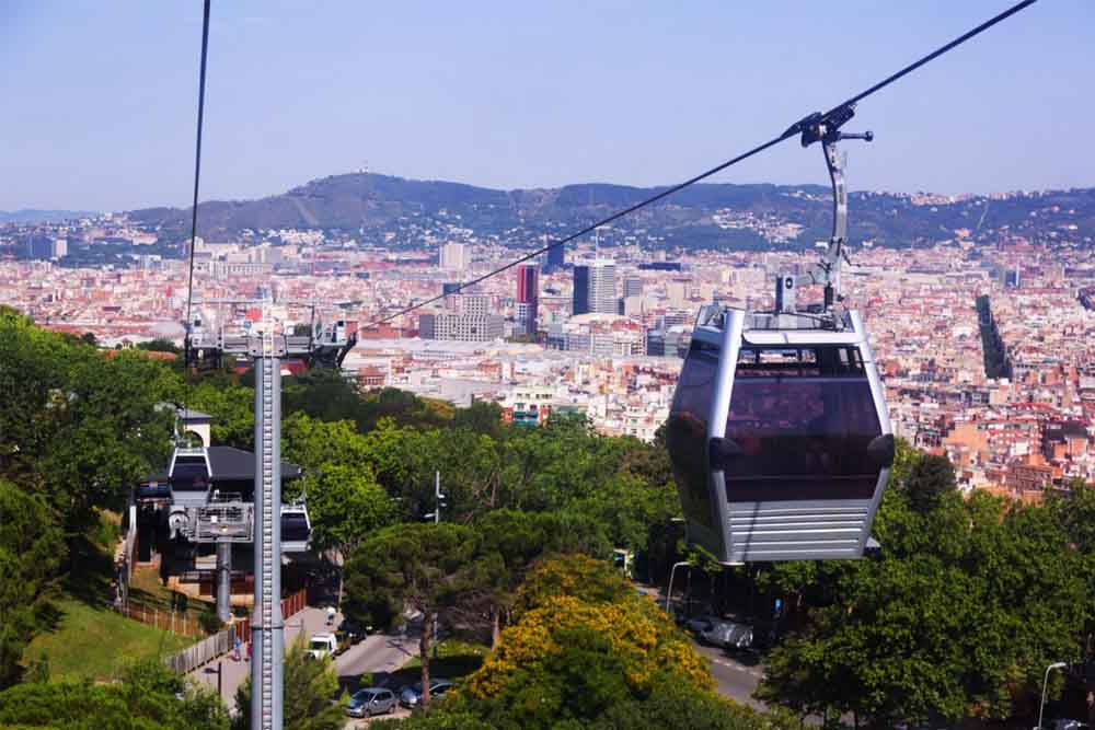 Montjuïc Cable Car Ticket Barcelona - Ride the Montjuïc Cable Car for unforgettable panoramic views of Barcelona. This scenic Barcelona cable car takes you from the city to Montjuïc Hill, offering breathtaking sights of landmarks, the harbor, and the Mediterranean. Perfect for capturing Barcelona from above! Montjuïc Cable Car Ticket Barcelona - Image 1 of 5
