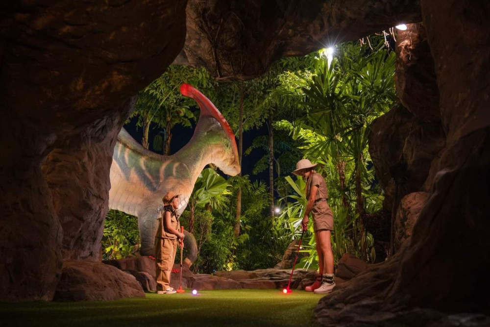 Dino Park Mini Golf - Experience the ultimate prehistoric adventure at Dino Park Mini Golf in Phuket! Dino Park Mini Golf offers 18 fun-filled holes surrounded by life-sized dinosaurs, erupting volcanoes, and lush jungle scenery. Snap photos with giant dinosaur statues and enjoy a unique mini-golf experience like no other. Dino Park Mini Golf is perfect for families, friends, and adventure seekers looking for a fun activity in Phuket. Don’t miss the chance to play, explore, and create unforgettable memories at Dino Park Mini Golf! Dino Park Mini Golf - Image 1 of 5