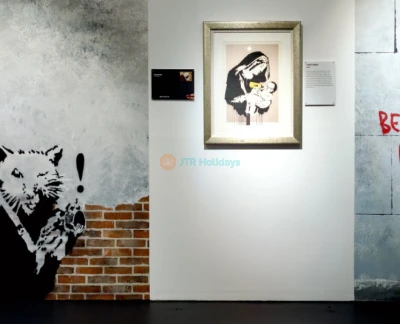 Banksy Museum New York - Explore the world of street art at Banksy Museum New York, home to over 160 recreated works by the legendary anonymous artist. Admire life-sized replicas of iconic pieces like Girl With Balloon and Rage, Flower Thrower at Banksy Museum New York. Dive into the powerful messages of satire and social commentary that define his art. Located in the historic Oltarsh Building, Banksy Museum New York offers an immersive experience for art lovers and fans of urban culture. Visit Banksy Museum New York for a journey into the mind of a street art legend! Banksy Museum New York - Image 2 of 5
