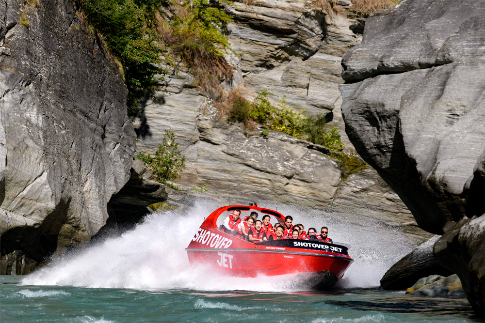 Shotover Jet Boat Ride - Experience the ultimate thrill with the Shotover Jet Boat Ride in Queenstown. Zoom through the iconic Shotover River at speeds of up to 85kph, navigating narrow canyons and performing exhilarating 360-degree spins. Marvel at the towering canyon walls and shallow waters as you race through this unique adventure. Enjoy free WiFi at the base to share your excitement instantly. An unforgettable, one-of-a-kind Queenstown experience awaits. Shotover Jet Boat Ride - Image 1 of 5
