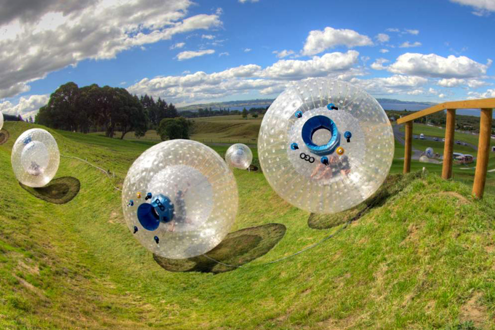 ZORB Aufblasbare Ball-Abenteuer - Rotorua - Erleben Sie den Nervenkitzel, auf den steilen Hügeln von Rotorua in einem aufblasbaren ZORB-Ball den Hang hinunterzurollen. Wählen Sie zwischen der kurvenreichen Sidwinder-Strecke oder der aufregenden Dual Straight-Strecke für puren Nervenkitzel. Ob allein oder mit Freunden, ZORB bietet ein spaßiges Abenteuer. Verpassen Sie nicht dieses einzigartige und mit Lachen gefüllte Erlebnis in Rotorua. ZORB Aufblasbare Ball-Abenteuer - Rotorua - Bild 1 von 5