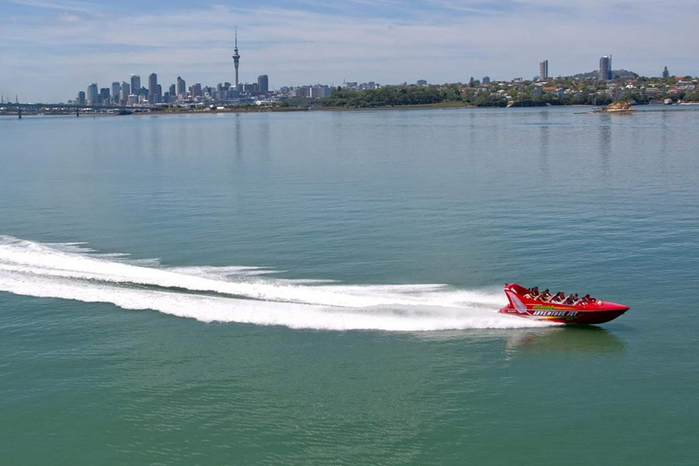 Auckland Abenteuer Jetbootfahrt - Spüre den Nervenkitzel bei der Auckland Abenteuer Jetbootfahrt, die über die atemberaubenden Gewässer des Hauraki Golfs rast. Genieße aufregende Drehungen, Wendungen und Drehungen, während du den atemberaubenden Blick auf die Skyline von Auckland und ikonische Wahrzeichen genießt. Erkunde Sehenswürdigkeiten wie die Chelsea Zuckerfabrik und die Klippen von Kauri Point. Erfahrene Guides sorgen für ein unvergessliches und sicheres Abenteuer. Auckland Abenteuer Jetbootfahrt - Bild 2 von 5