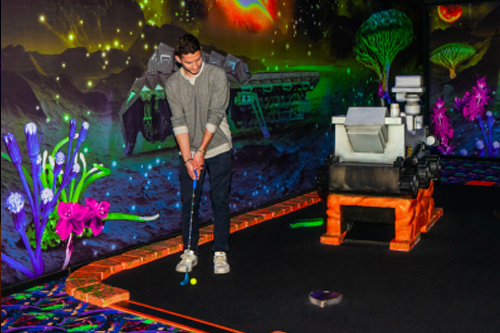Blacklight Mini Golf at American Dream - Experience the glow-in-the-dark fun of Blacklight Mini Golf at American Dream! Challenge yourself on an exciting 18-hole course with unique obstacles and vibrant neon artwork. Capture memorable moments in this immersive and interactive mini golf adventure. Book your Blacklight Mini Golf ticket now for an unforgettable experience! Blacklight Mini Golf at American Dream - Image 3 of 5