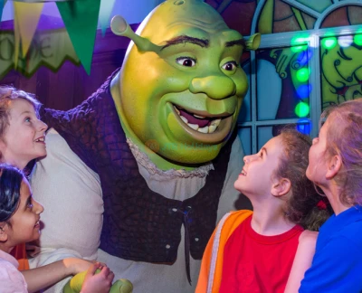 L'Aventure de Shrek à Londres - Entrez dans l'univers de Shrek avec L'Aventure de Shrek à Londres, une expérience interactive pleine de divertissement pour tous les âges. Profitez d'un trajet en bus volant 4D, de spectacles en direct et d'effets spéciaux lors de votre voyage à Très Très Loin. Rencontrez Shrek, l'Âne et d'autres personnages adorés. Réservez vos billets pour L'Aventure de Shrek à Londres dès aujourd'hui ! L'Aventure de Shrek à Londres - Image 5 sur 5