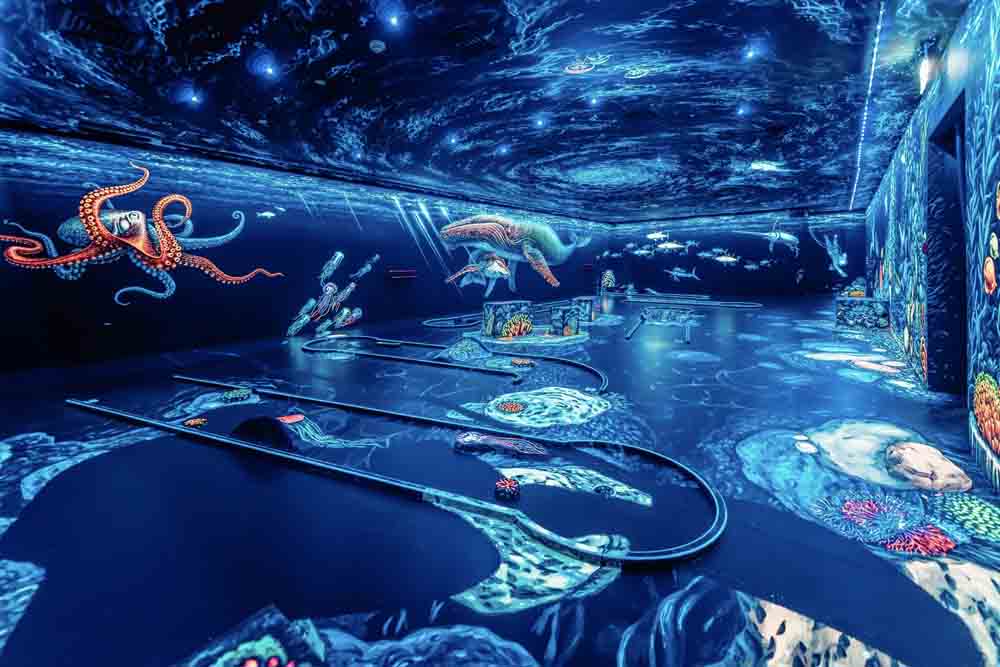 3D Blacklight Minigolf Dubai Tickets - We transport you to a unique black-light indoor minigolf setting the floor, walls, and ceilings of the entire course are beautified with bright and colorful images, hand-painted by the world's best 3d artists. 3D Blacklight Minigolf on a Galactic Scale. The black-lit minigolf course with glowing balls & space-themed artwork viewed through 3D glasses. 3D Blacklight Minigolf Dubai Tickets - Image 2 of 5