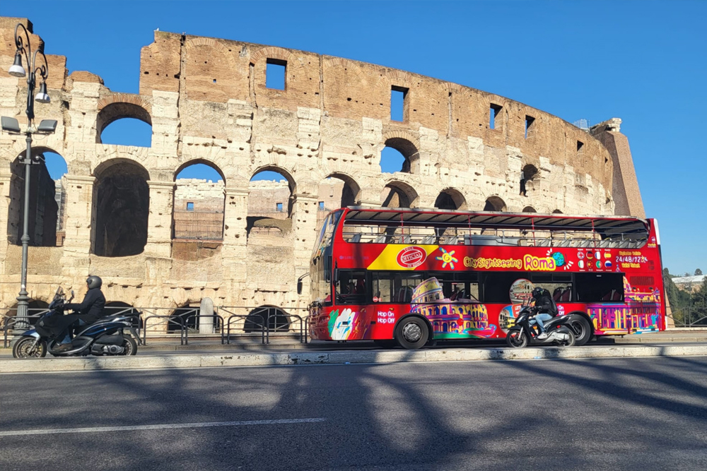 Rome Hop-On Hop-Off Bus by City Sightseeing - Explore Rome with the City Sightseeing Hop-On Hop-Off Bus and visit top attractions at your own pace. Travel on an open-top double-decker bus with stunning views of the Colosseum, Vatican City, and more. Enjoy an audio guide available in multiple languages as you discover Rome’s history and culture. Choose from 24, 48, or 72-hour tickets for a flexible sightseeing experience. Rome Hop-On Hop-Off Bus by City Sightseeing - Image 3 of 5