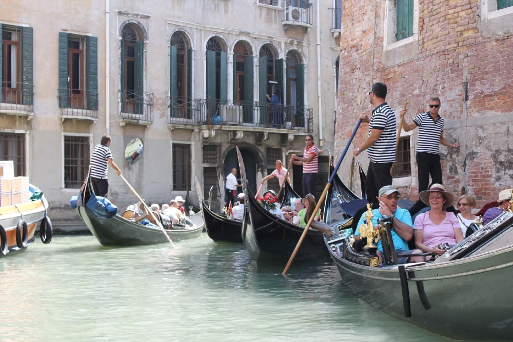Grand Canal Romantic Gondola Ride in Venice - Enjoy a Grand Canal Romantic Gondola Ride in Venice and glide through historic waterways. Admire stunning palaces, charming bridges, and iconic landmarks from a traditional gondola. Experience the romance of Venice as your gondolier guides you through hidden canals. Book your gondola ride for an unforgettable Venetian adventure. Grand Canal Romantic Gondola Ride in Venice - Image 1 of 5